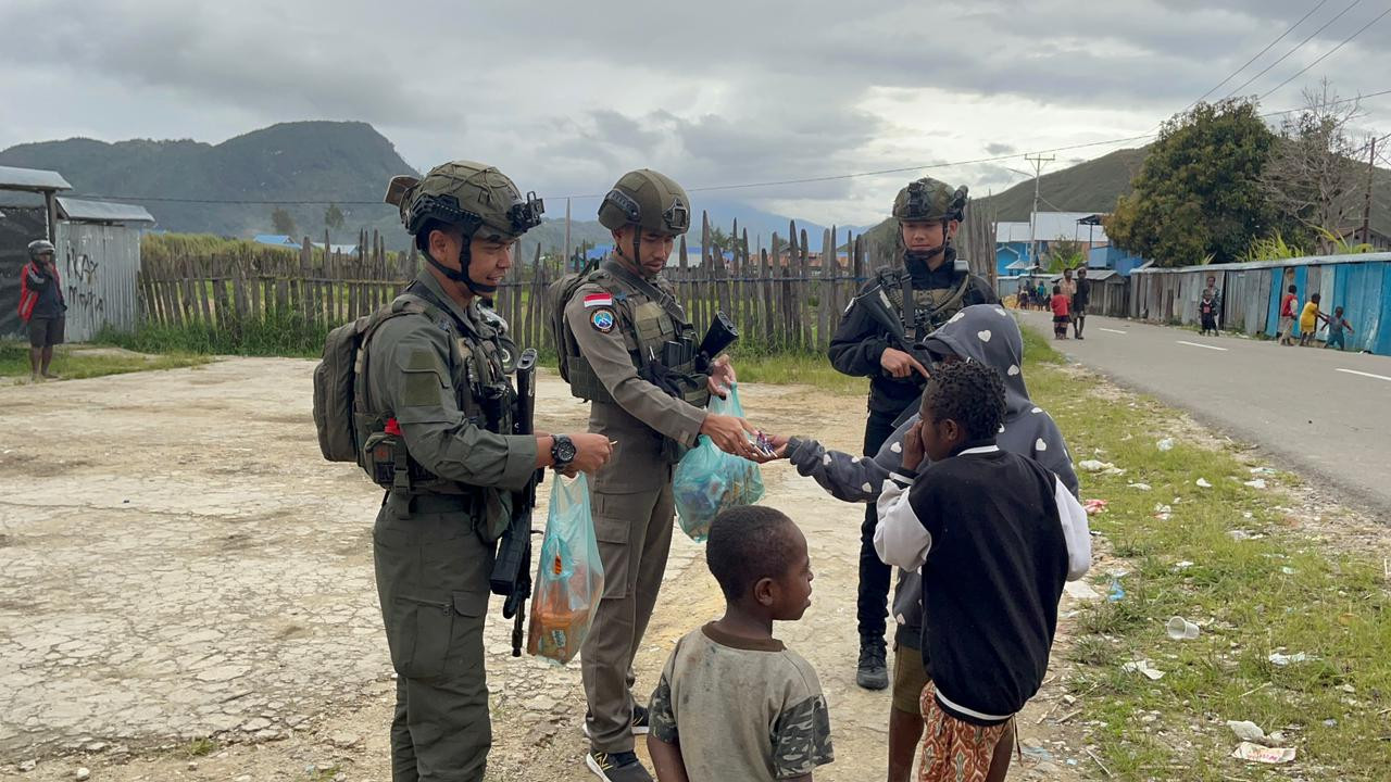 Personel Ops Damai Cartenz Berbagi Kebahagiaan Bersama Warga dan Anak-anak di Enarotali