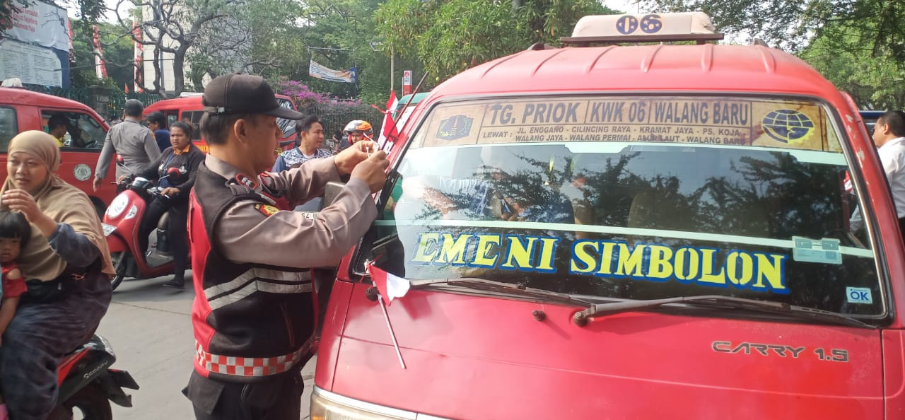 Polsek Koja Bagikan 100 Bendera Merah Putih Kecil kepada Pengendara di Jl. Kramat Jaya