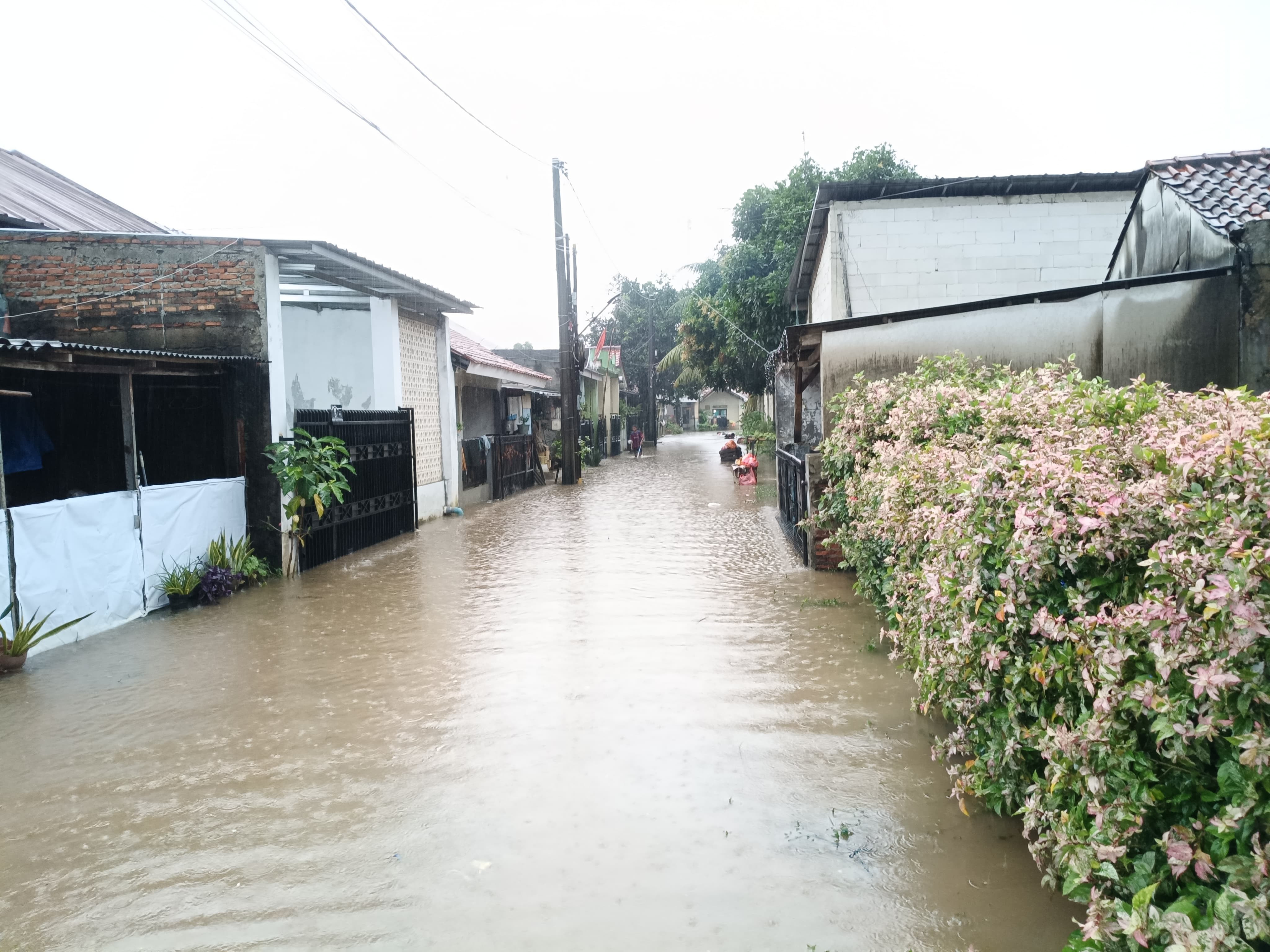 Hujan Intensitas Tinggi, Bhabinkamtibmas Polsek Bantargebang Pantau Genangan Air di Perumahan Kota Baru Cimuning