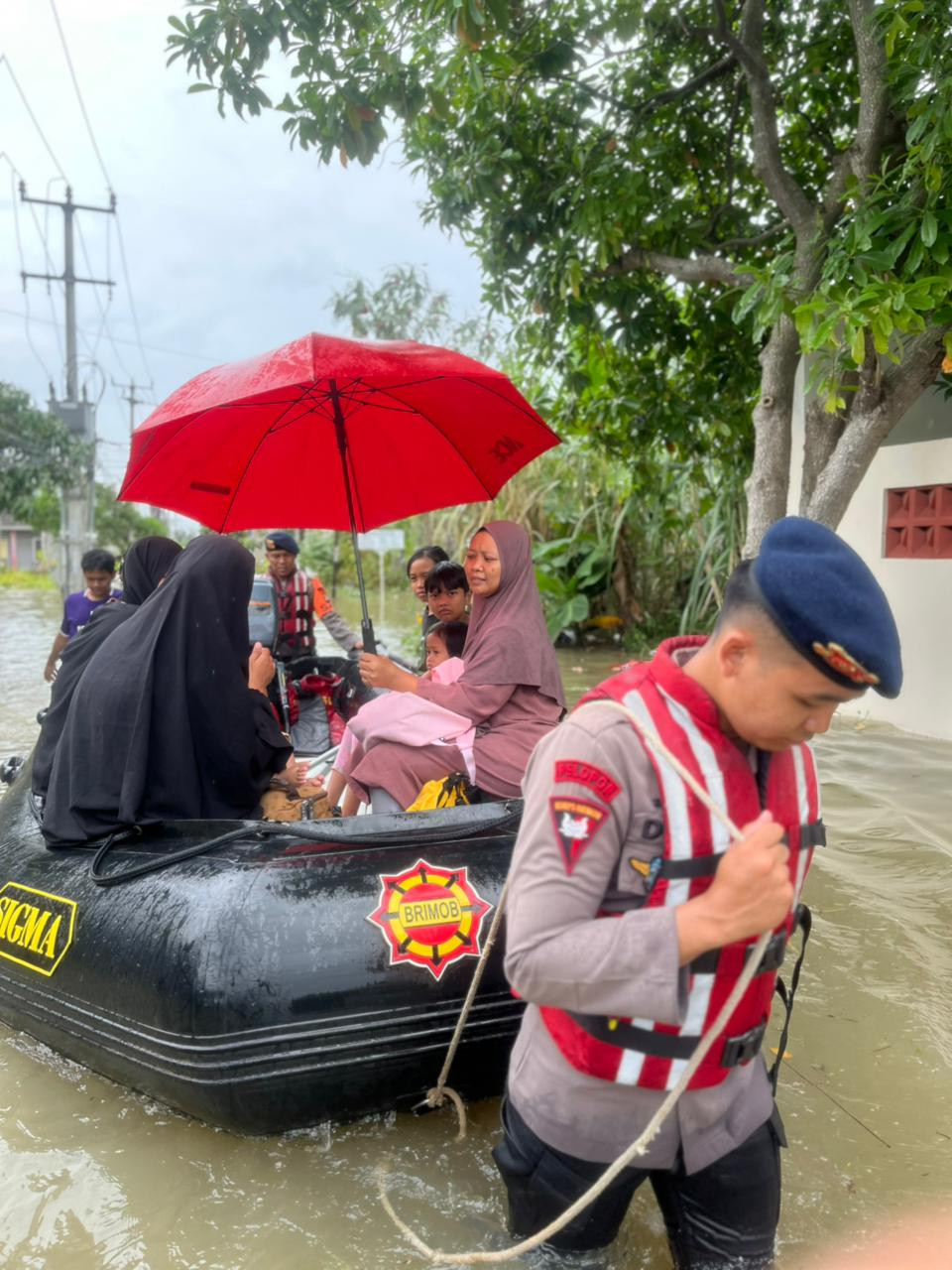 Emak-emak Hingga Nakes Naik Perahu Karet Brimob Sebrangi Banjir