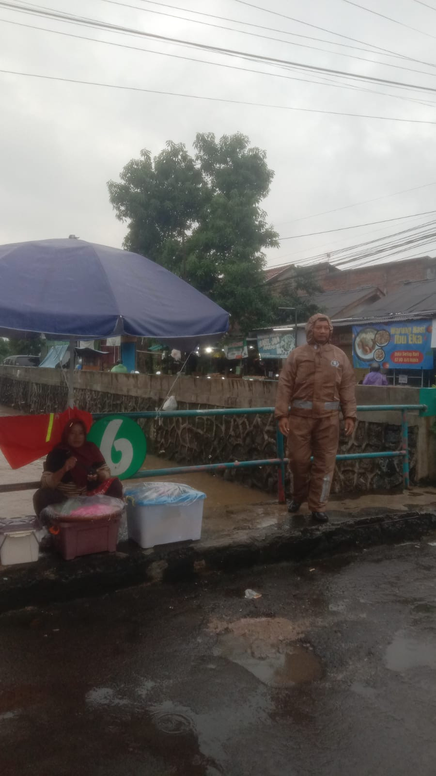 Pasca Hujan, Bhabinkamtibmas Polsek Bantargebang Pantau Debit Air Kali Pete di Perumahan PTI II