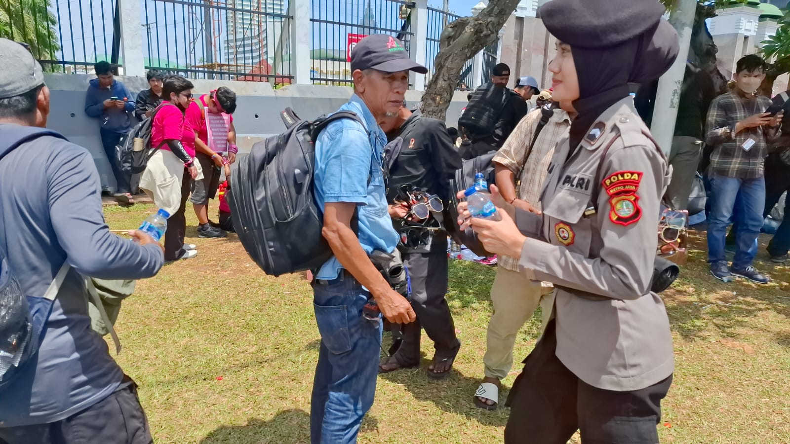 Polwan Polda Metro Bagikan Air Mineral ke Massa Aksi di Depan DPR/MPR