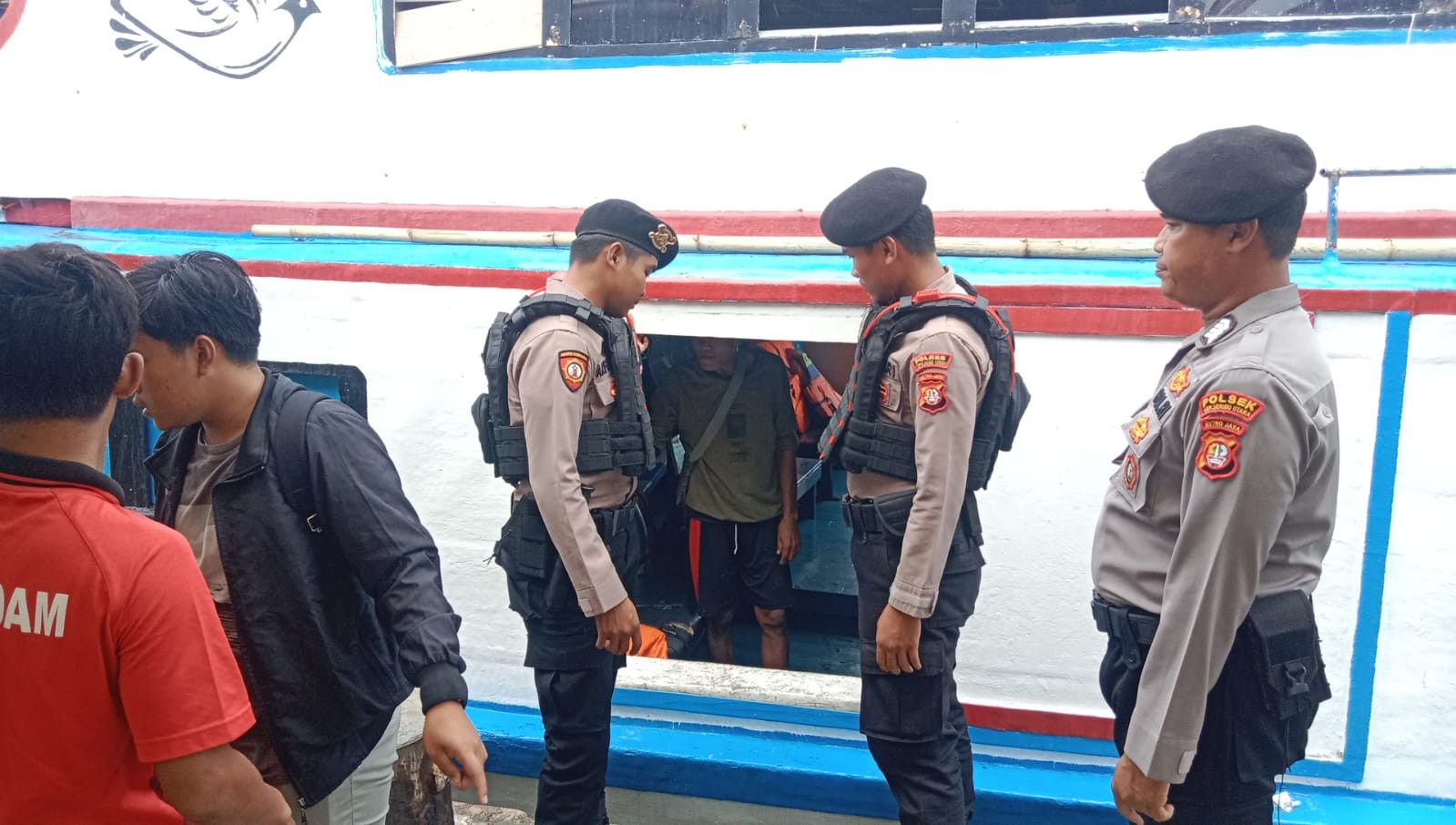 Polisi Baik Polsek Kepulauan Seribu Utara Bantu Penumpang Turun dari Kapal di Dermaga