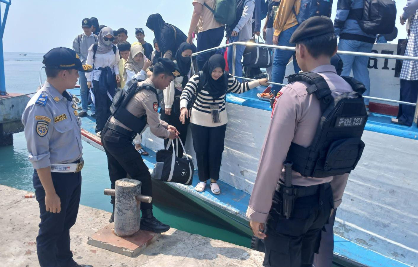 Polisi Humanis Polsek Kepulauan Seribu Utara Bantu Penumpang Turun dari Kapal dan Awasi Barang Bawaan