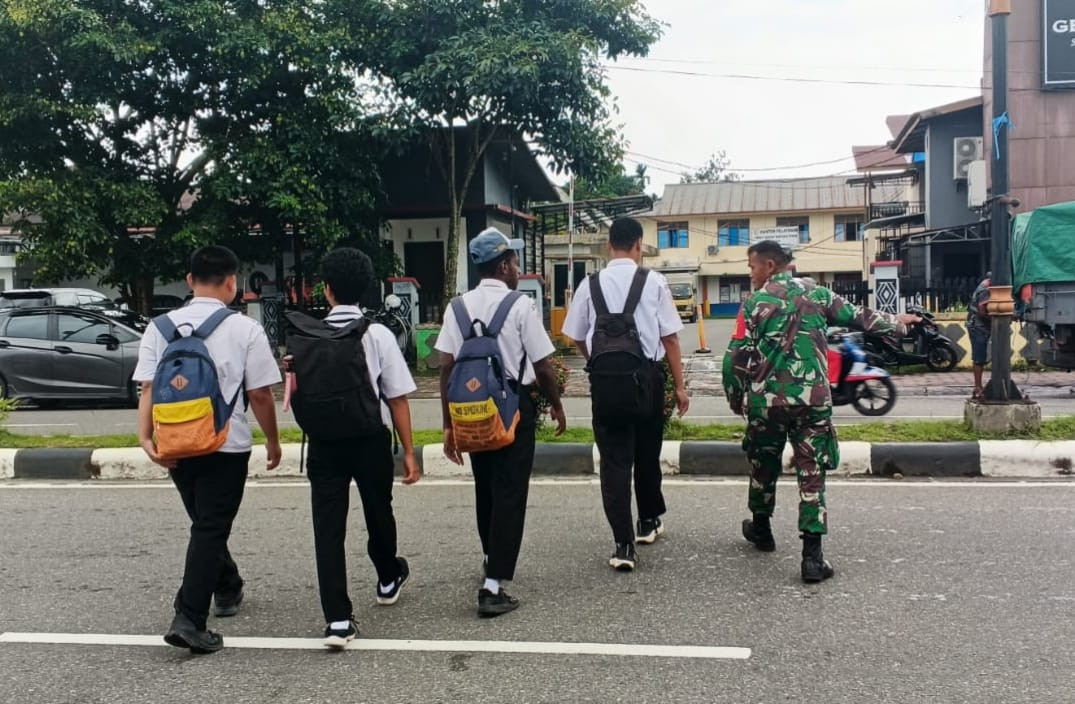 Peduli Keselamatan Anak Sekolah, Secara Rutin Babinsa Koramil Jajaran Kodim 1710/Mimika Bantu Seberangkan Jalan